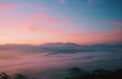 Scenic view of dramatic sky over silhouette landscape during sunset