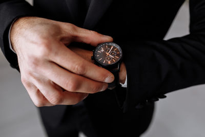 Midsection of businessman holding navigational compass