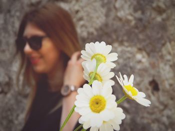 Close-up of woman holding white flowering plant