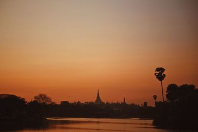 Silhouette of temple building against sky during sunset