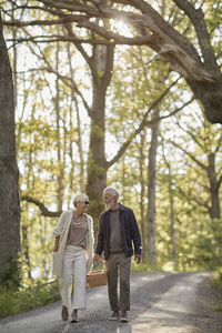 Couple carrying picnic basket together