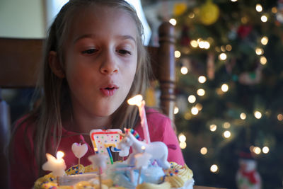 Close-up of girl blowing birthday cake