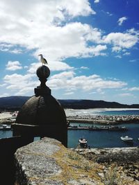 Statue on beach against sky