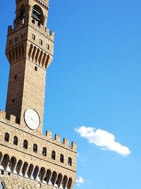 Low angle view of clock tower against blue sky