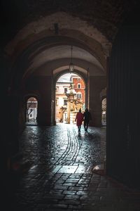 Rear view of people walking in corridor of building