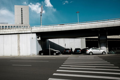 Cars on bridge against sky in city