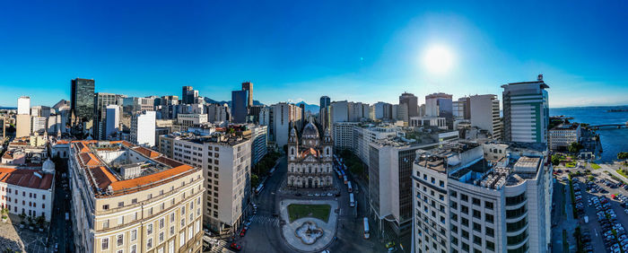 Buildings in city against clear blue sky