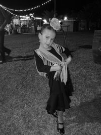 Full length portrait of girl in traditional dress posing on field at night