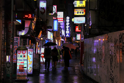 People walking in illuminated city at night