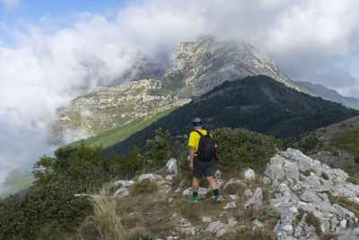 Man standing on rocks against mountains