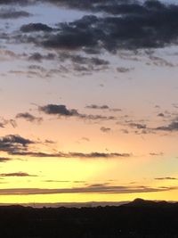 Scenic view of dramatic sky over silhouette landscape