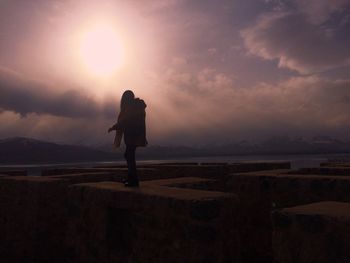 Rear view of silhouette man standing against sky during sunset