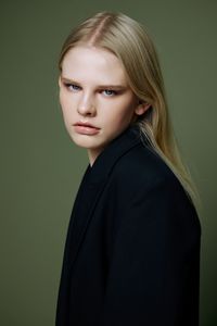 Portrait of young woman against wall