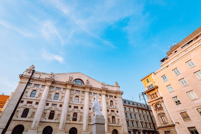 Wide angle view of piazza degli affari in milan with famous artwork in the center