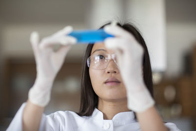 Scientist female with lab glasses and tubes in a lab