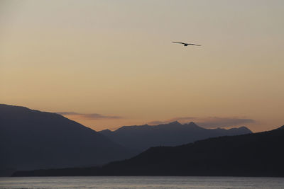 Scenic view of sea and mountains against clear sky