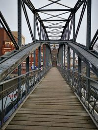 Rear view of man walking on footbridge