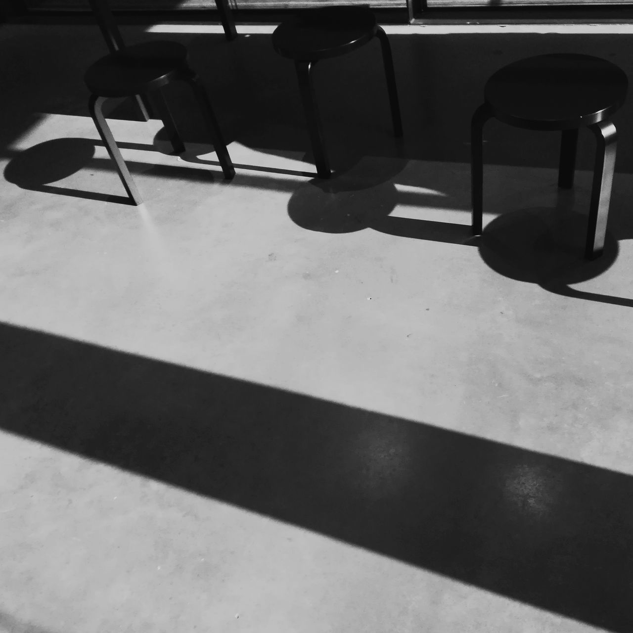 HIGH ANGLE VIEW OF EMPTY CHAIRS AND TABLE IN TILED FLOOR