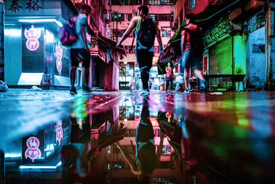 People standing in illuminated city at night