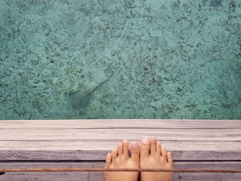 Low section of person relaxing in swimming pool