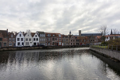 River by buildings against sky in city