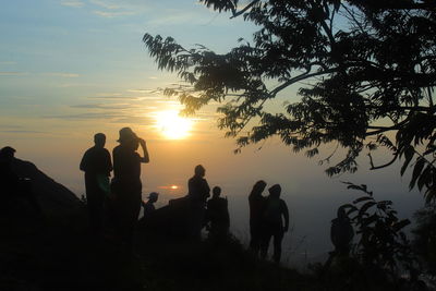 Silhouette people against sky during sunset