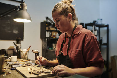 Jeweller working at workbench in workshop