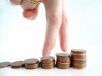 Close-up of hand holding stack against white background