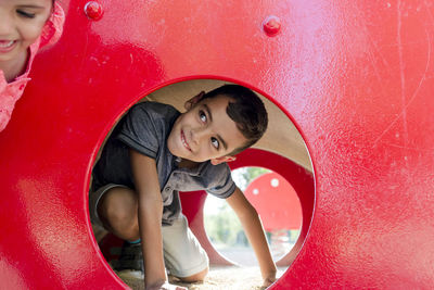 Two kids having fun playing together on a playground in a park.