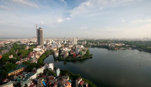 High angle view of buildings by river against sky