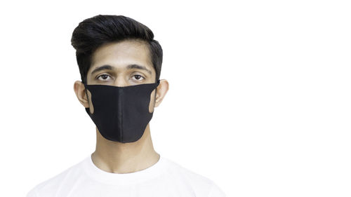 Portrait of teenage girl covering face against white background