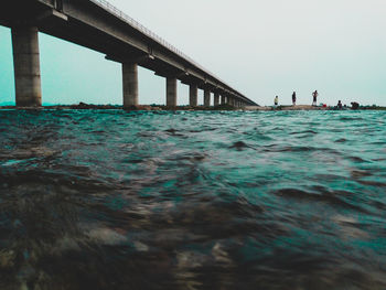 Bridge over sea against clear sky