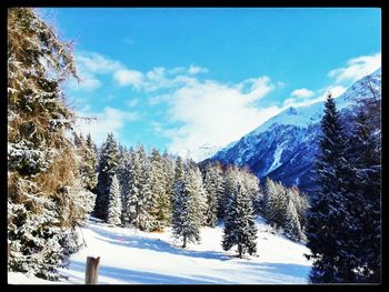 Scenic view of snow covered mountains against blue sky