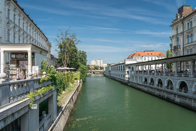 Canal amidst buildings in city against sky