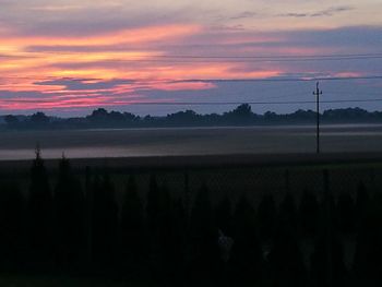 Scenic view of silhouette field against sky during sunset