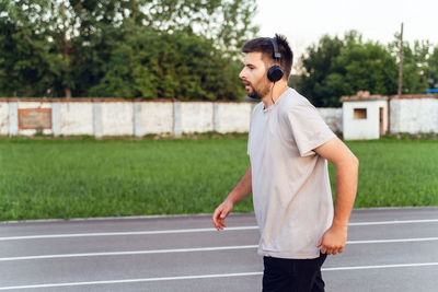 Side view of young man standing outdoors