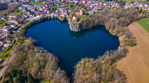 High angle view of lake amidst trees and buildings in city