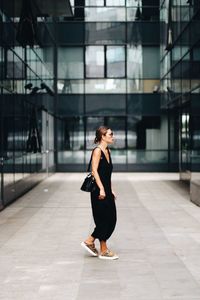 Full length side view of young woman in city