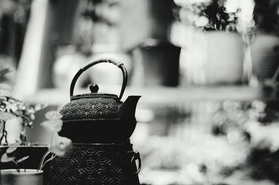 Close-up of teapot by flower pot