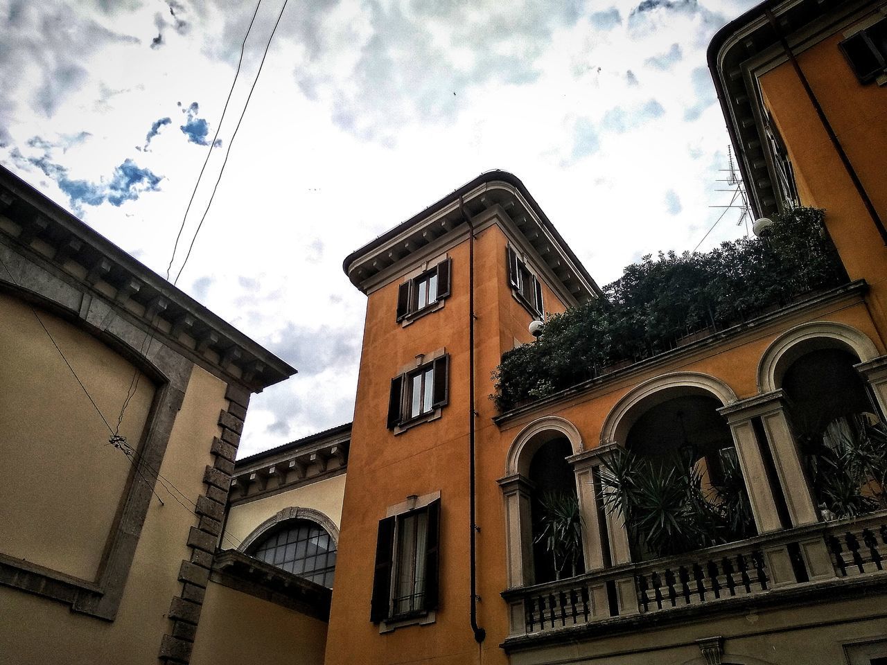 LOW ANGLE VIEW OF BUILDINGS AND TREES AGAINST SKY