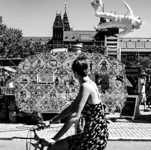 Rear view of woman against buildings in city
