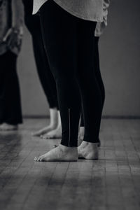 Low section of women standing on tiled floor