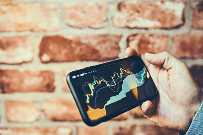 Person investing trading on stock cryptocurrency market using investing application on smartphone