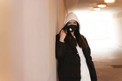 Portrait of woman standing against wall