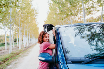 Woman with umbrella while sitting in car