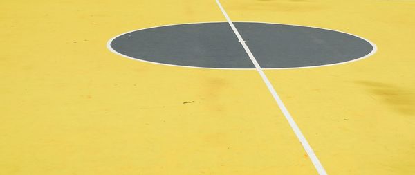 Close-up of basketball hoop against yellow background