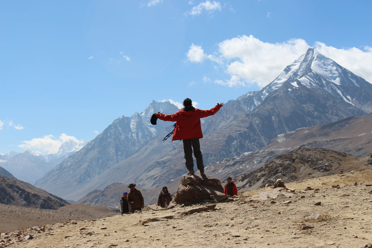 MAN STANDING ON MOUNTAIN