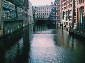 Bridge over river in city against sky