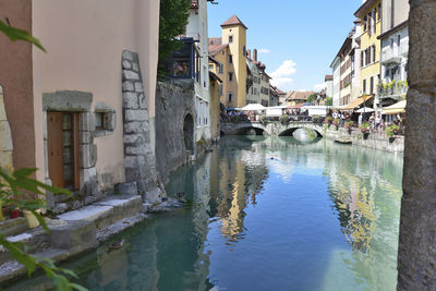 Canal amidst buildings in town against sky