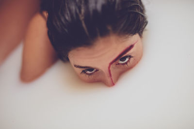 Close-up portrait of young woman taking milk bath